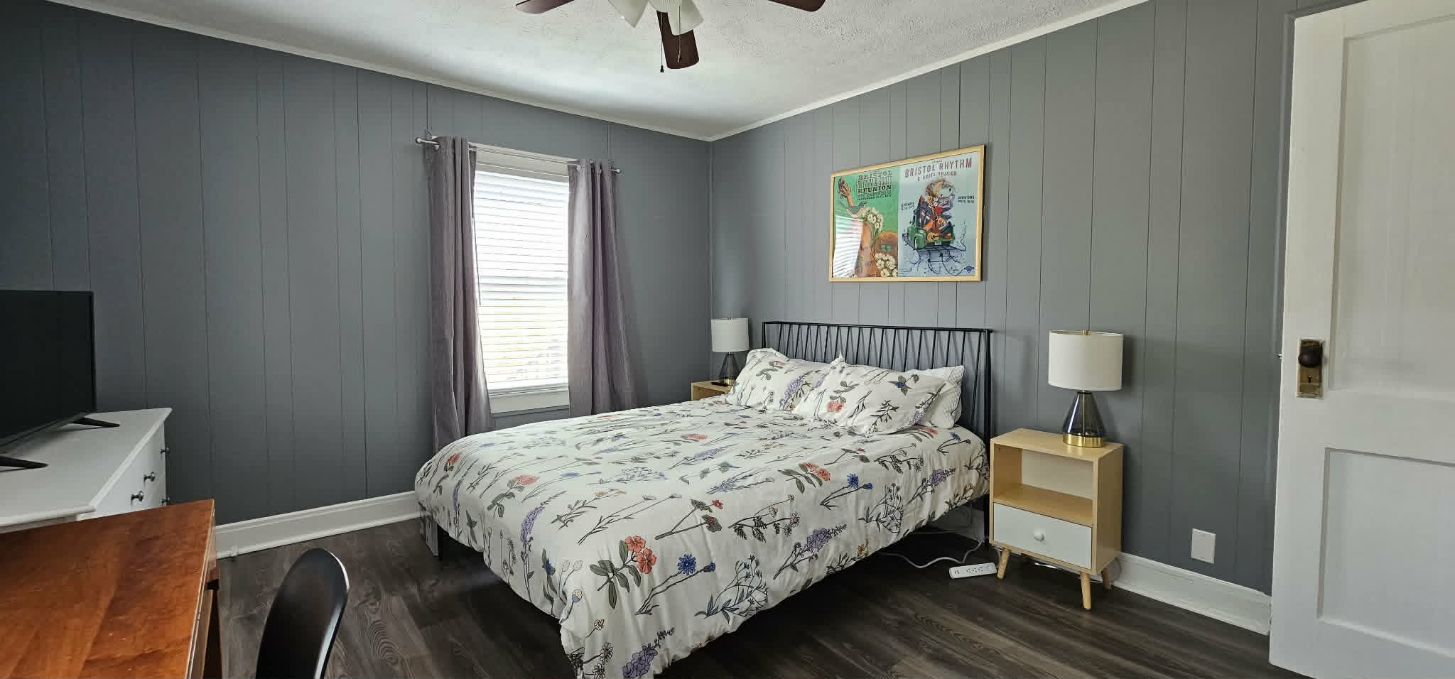 Bedroom with queen bed, desk, and dresser